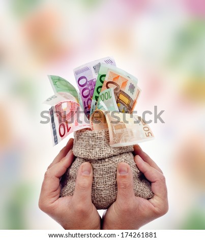 Praising money concept - male hands holding bag of euro banknotes