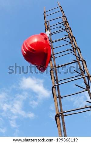 Construction industry still life with helmet hanging on steel bars