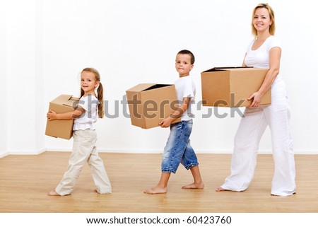 Family moving in to a new home carrying cardboard boxes
