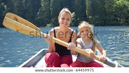 Woman and little girl in a small boat holding the  paddle