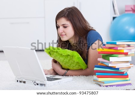 Teenager girl researching for a school project in books and on the internet