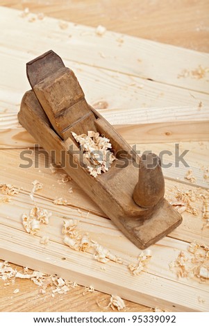 Wood planks, old style plane and wooden shavings - closeup