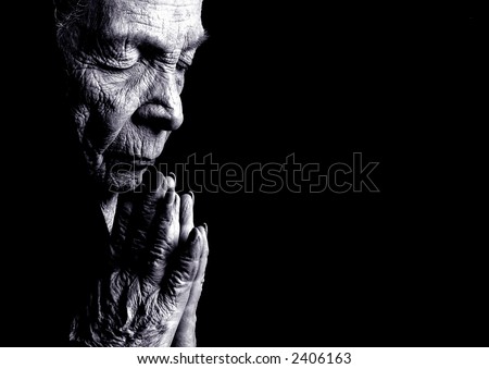 stock photo : Portrait on Black Of Old woman Praying