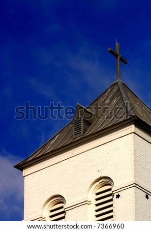 Lone church against perfect blue sky with cross