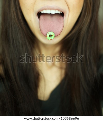 Young Woman with Round Green Breakfast Cereal on Tongue