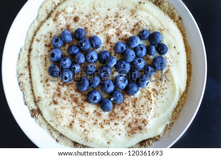Bowl of cheese cake and graham cracker crust with fresh blueberries