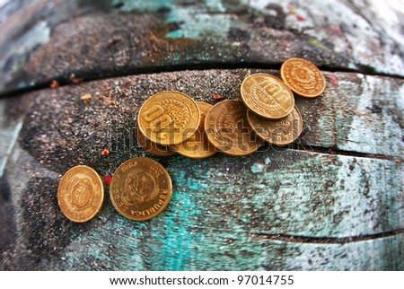 Costa Rican colones currency sits on old picnic table with sand