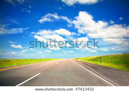 Empty highway in Midwest with green grass and blue sky in summer en route to Chicago