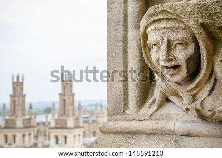 Carved Gargoyle Figure and All Souls College from St. Mary The Virgins Church. Oxford, England