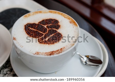 Cup of cappuccino with coffee beans shaped design