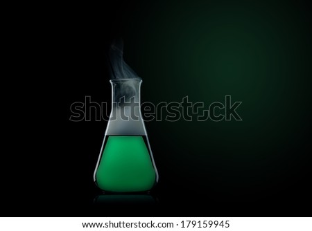 flask with green liquid to the black background