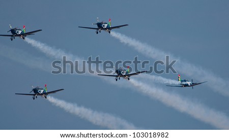 PRETORIA, SOUTH AFRICA -12 MAY 2012 - A solo Astra flies between 4 other Silver Falcons  during  the Swartkop Warbird Centenary airshow on 12 May 2012 at Swartkop Airforce Base