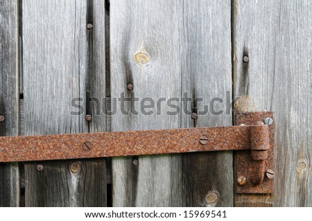 Rusty hinge on old unpainted panel door