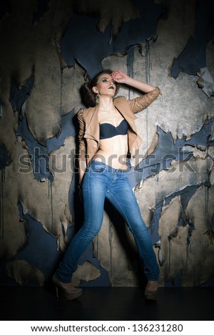 Girl in casual outlook over burned background, studio shot