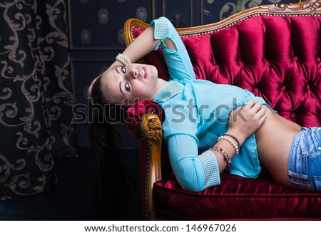 Girl laying on red sofa, close up shot