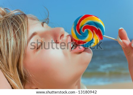 Sensual girl licking candy on sea background