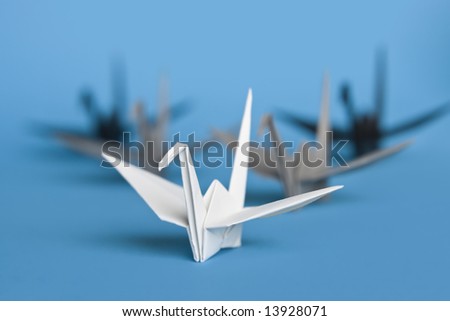 A group of five origami birds forming a v pattern