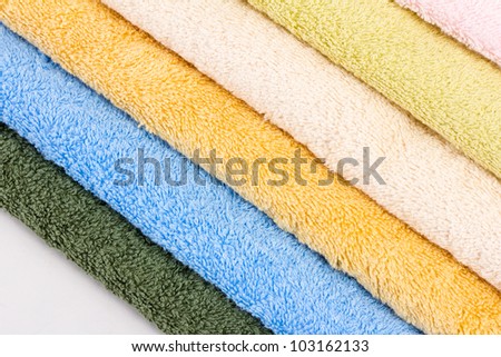 six new dry colored towels on white background in studio
