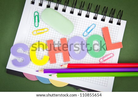 letters with pencils, paper clips, by an eraser on notebook