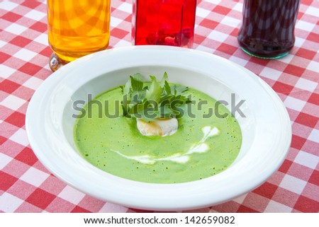green vegetable soup with parsley, in a restaurant, on a table-cloth