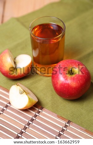 cut and whole apples with to apple juice in glass