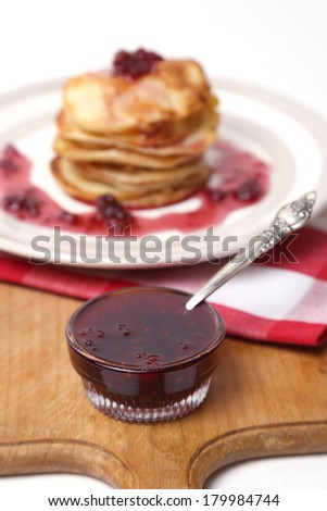 few fresh pancakes with a strawberry sauce on a dish