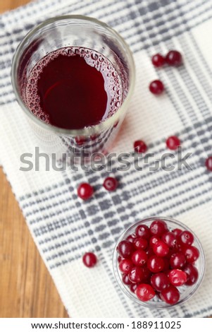ripe wet cranberries and juice on wooden background