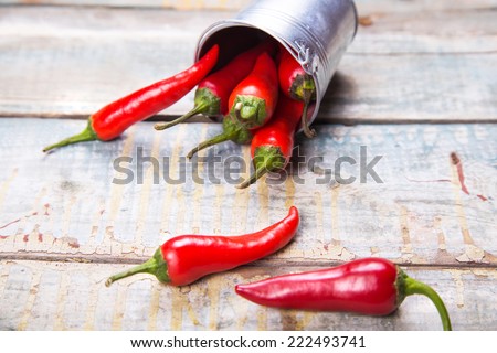 few ripe pods of very spice pepper are on a wooden background