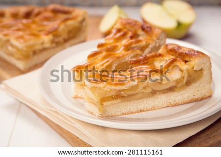 pieces of fresh apple-pie with filling on a wooden background