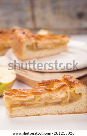 piece of fresh apple-pie with filling on a wooden background