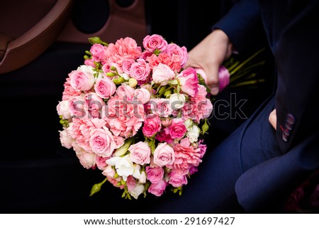 Big roses bouquet in men hand in car