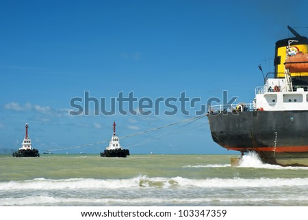 Tanker towing Cargo ship run aground on rocky  shore