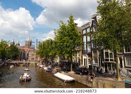 AMSTERDAM,THE NETHERLANDS - August 3, 2014: People moving boat on the canals of Amsterdam. Known and loved by way of entertainment and leisure in Amsterdam.