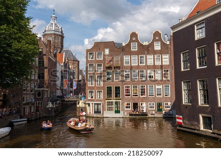 AMSTERDAM,THE NETHERLANDS - August 3, 2014: People moving boat on the canals of Amsterdam. Known and loved by way of entertainment and leisure in Amsterdam.