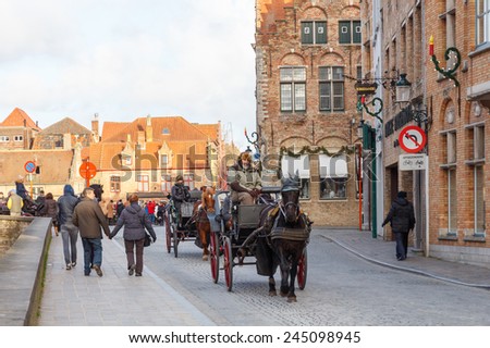 Bruges, Belgium - December 25, 2014: Horse-drawn carriage on the ancient streets of Bruges. Popular activities among tourists.