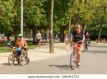 Amsterdam, Netherlands - August 5, 2014:  Cyclists and wheelchair users on the cycling road Vondelpark in Amsterdam.
