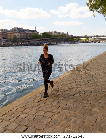 Paris, France - May 3, 2014: Embankment of the river Seine in Paris. Favorite place for walks and sports. Sports girl running along the waterfront.