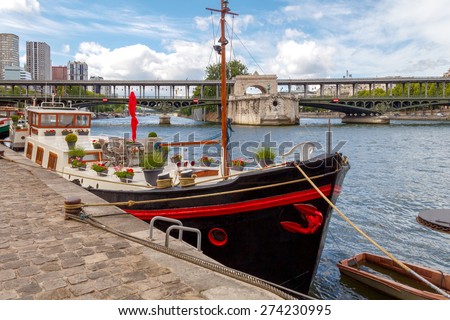 Paris, France - May 9, 2014: Floating house Ships for the river Seine near the Swan Island in Paris.