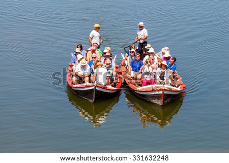 Florence, Italy - May 18, 2015: Water tourist boat trips on the river Arno. Local gondola are very popular among tourists.