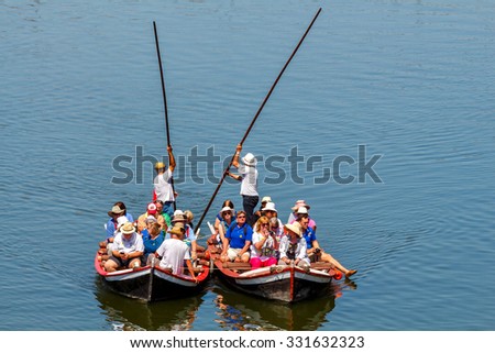 Florence, Italy - May 18, 2015: Water tourist boat trips on the river Arno. Local gondola are very popular among tourists.