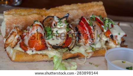 skewers of shrimp in garlic sauce with tomatoes onions and various spices on a wooden board