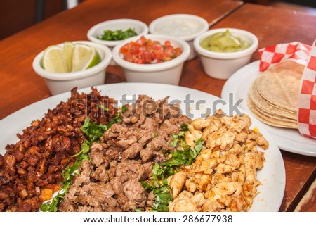 three meats, chicken, pork and beef fried and seasoned on a white plate