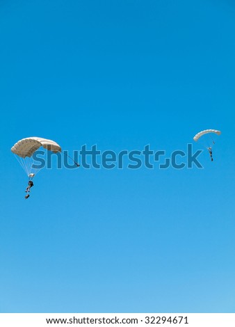 Group of white parachute jumpers  against pure blue sky
