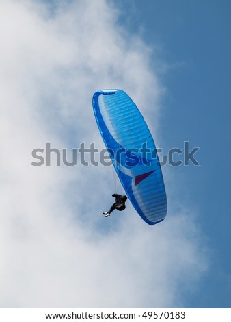 man paragliding over pure blue sky