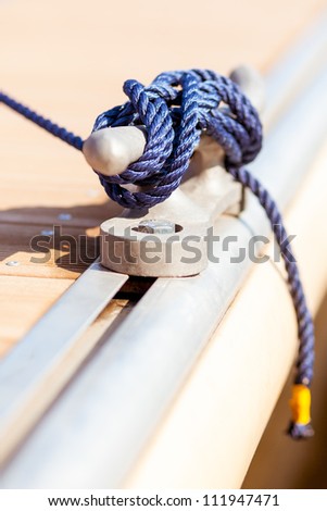 Closeup of blue mooring rope tied around steel anchor on boat or ship/ Blue mooring rope on ship