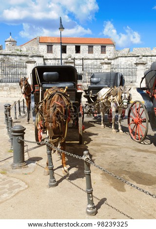 Horse drawn carriages parked in Plaza de Armas, Old Havana