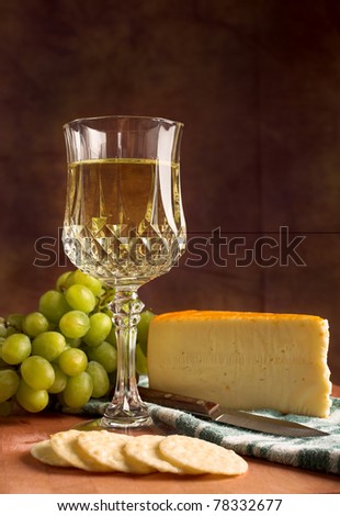 Fine Dining glass of white wine accompanied by cheese, green grapes and crackers