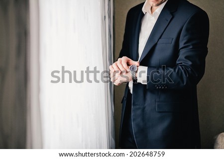 Businessman holding hand with wrist watches in pocket isolated on white