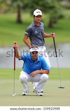NAKHONPATHOM,THAILA ND - AUG 9:Andre Stolz (blue) of AUS  lines up prior to putting during hole9 day one of the Golf Thailand Open at Suwan Golf&Country Club on August 9, 2012 in Nakhonpathom Thailand