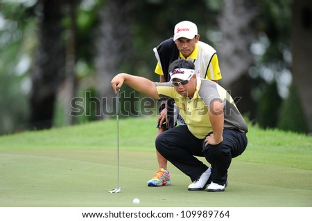 NAKHONPATHOM,THAILA ND-AUG 10:Kiradech Aphibarnrat of THA with caddy lines up a shot during  day two of the Golf Thailand Open at Suwan Golf Club on August 10, 2012 in Nakhonpathom Thailand